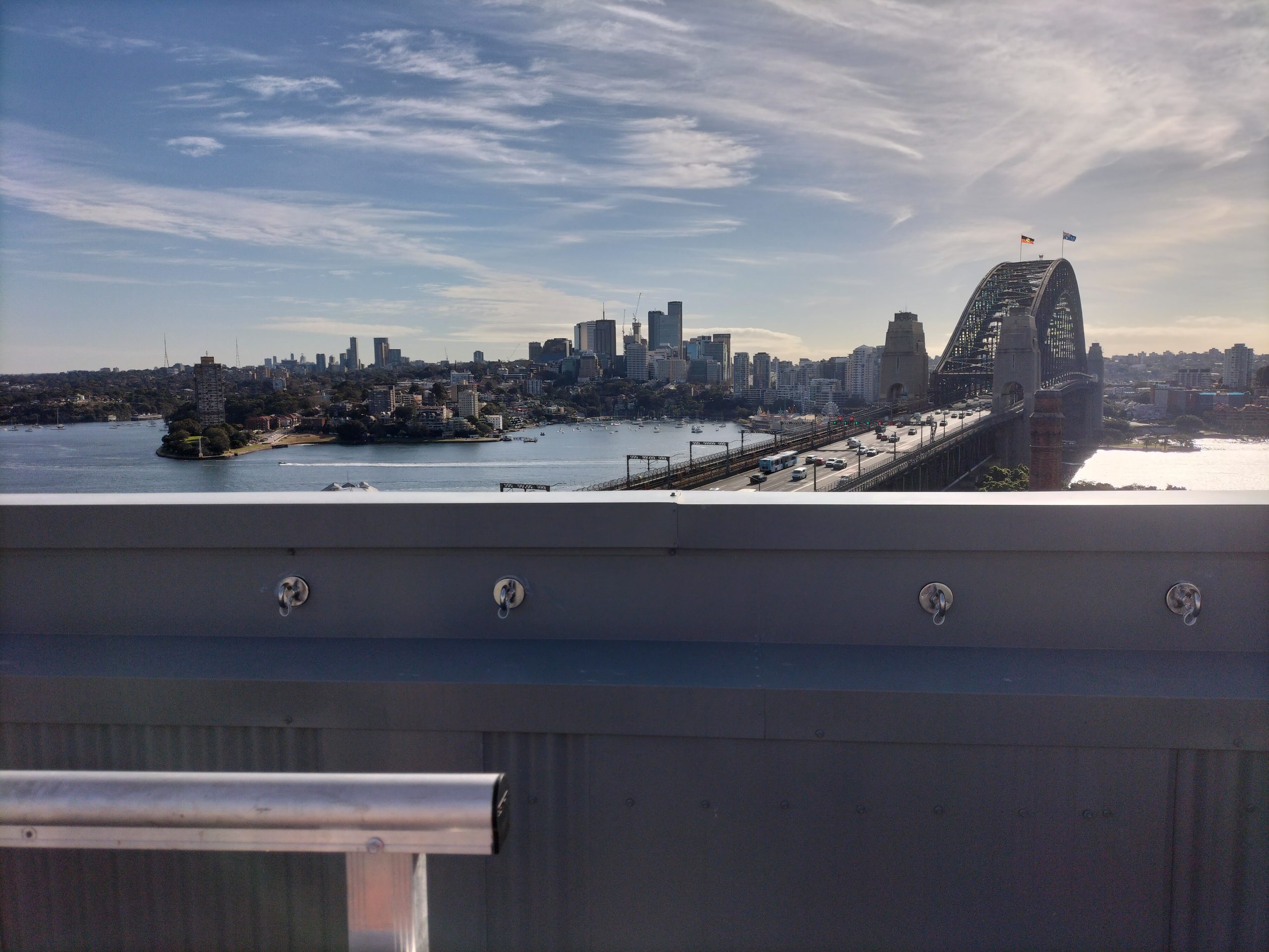 Row of anchor points fixed along a rooftop parapet at Sirius in The Rocks, with the Sydney Harbour Bridge behind